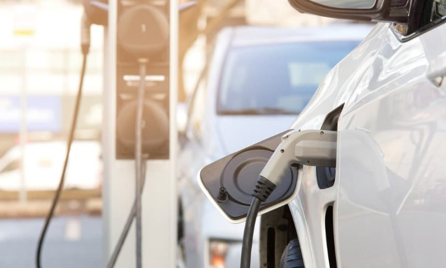 A line of electric vehicles hooked to charging stations.