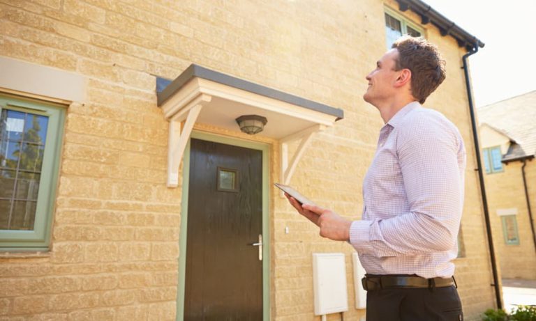 A community management professional inspecting a property for damage.